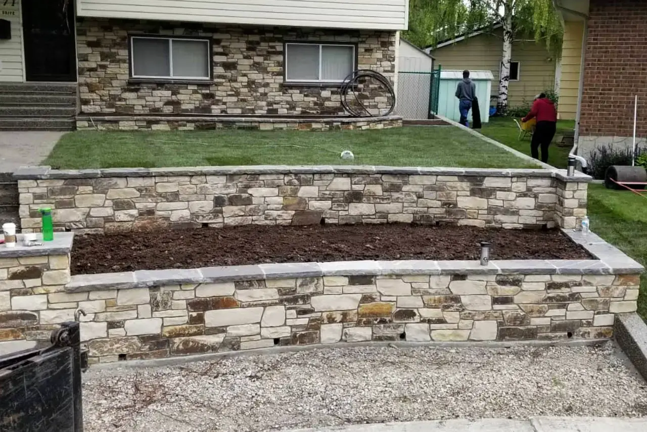 Expertly crafted natural stone retaining wall and pathway enhancing a property.